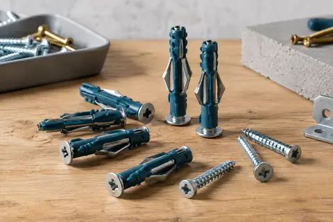 Chevilles Fischer DuoHM bi-matière avec vis à empreinte PZ posées sur un établi en bois